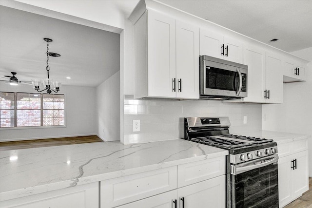 kitchen with white cabinetry, light stone countertops, and appliances with stainless steel finishes