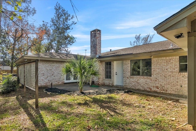 rear view of property featuring a patio area and a yard