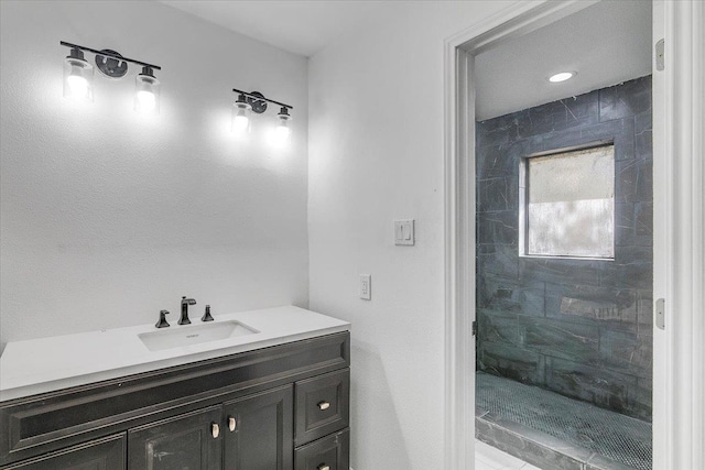 bathroom featuring a tile shower and vanity