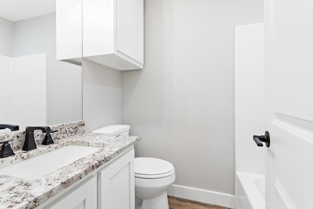 full bathroom with wood-type flooring, vanity, shower / bath combination, and toilet