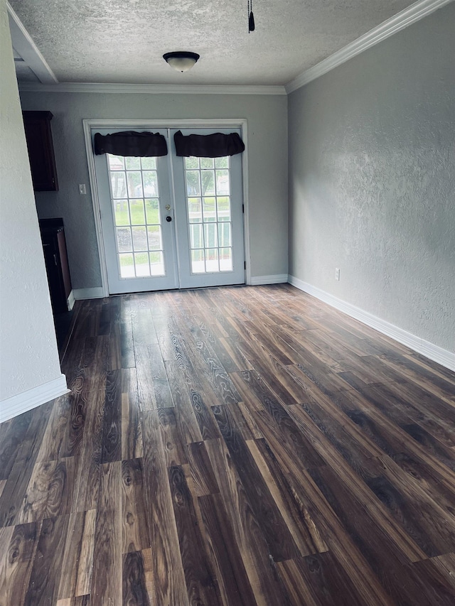 unfurnished room featuring french doors, dark wood-type flooring, a textured ceiling, and ornamental molding