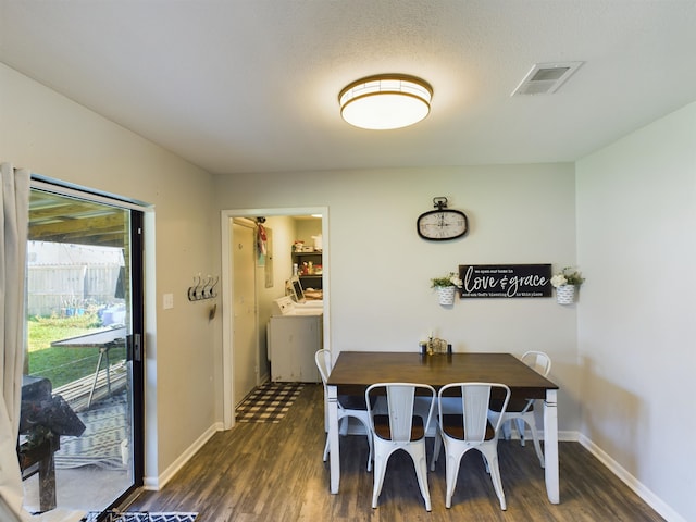 dining area with a textured ceiling, washer and clothes dryer, and dark wood-type flooring