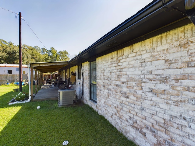 view of side of property featuring central AC unit, a patio area, and a yard