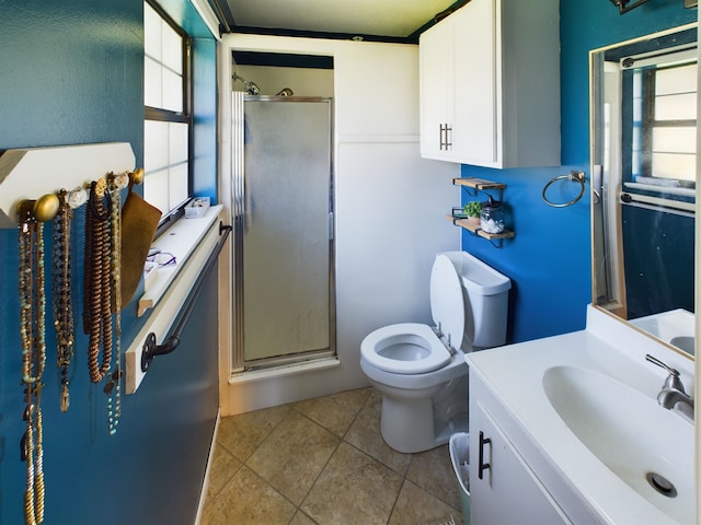 bathroom with tile patterned flooring, vanity, toilet, and a shower with shower door