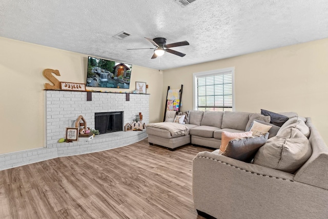 165 Trahan Rd, Lumberton, TX 77657 - living area featuring wood finished floors, a ceiling fan, a textured ceiling, and a fireplace