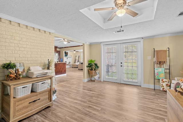 165 Trahan Rd, Lumberton, TX 77657 - interior space featuring a ceiling fan, a textured ceiling, ornamental molding, light wood-style flooring, and french doors