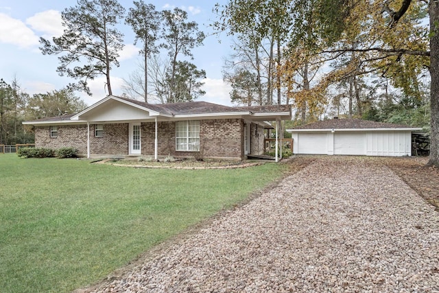 ranch-style home featuring a garage, an outbuilding, and a front lawn