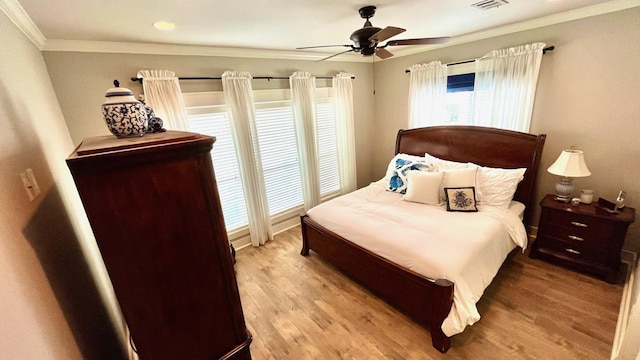 bedroom featuring light hardwood / wood-style flooring, ceiling fan, and ornamental molding