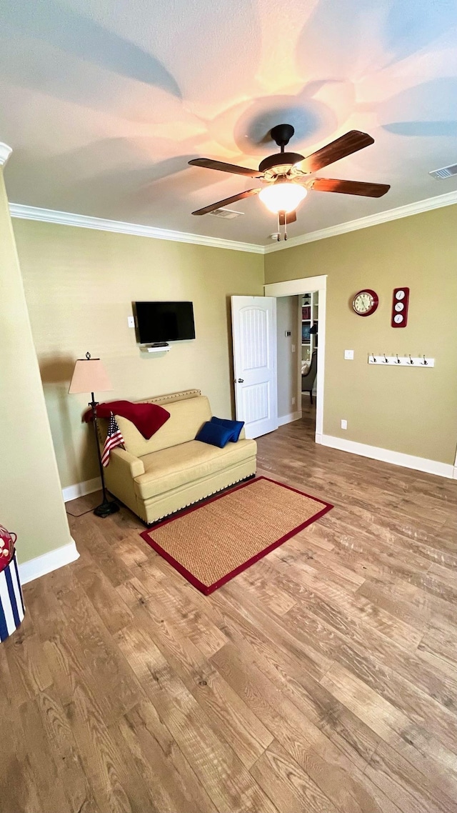 living room with ceiling fan, wood-type flooring, and ornamental molding