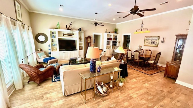 living room with ceiling fan, ornamental molding, and light wood-type flooring