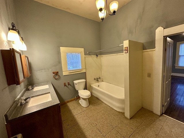 full bathroom featuring washtub / shower combination, an inviting chandelier, vanity, and toilet