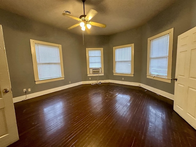 unfurnished room featuring ceiling fan, cooling unit, dark wood-type flooring, and a textured ceiling