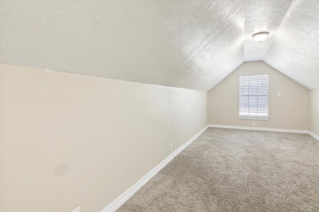 bonus room with a textured ceiling, lofted ceiling, and carpet floors