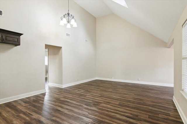 unfurnished living room with dark hardwood / wood-style floors, high vaulted ceiling, and a chandelier