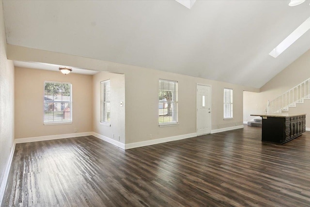 unfurnished living room with dark hardwood / wood-style flooring and vaulted ceiling with skylight