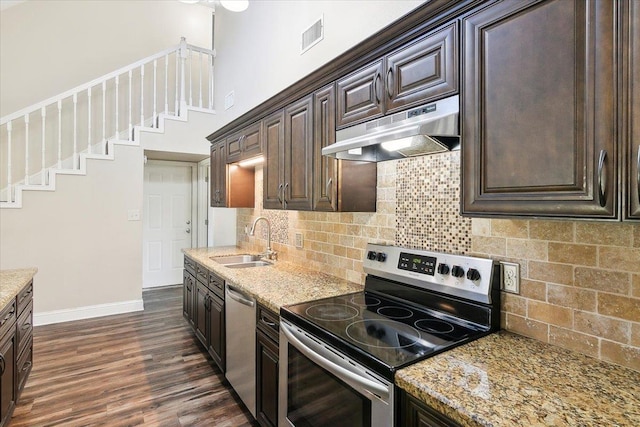 kitchen with backsplash, sink, dark hardwood / wood-style floors, appliances with stainless steel finishes, and light stone counters