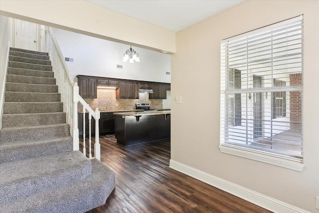 stairway featuring wood-type flooring and an inviting chandelier