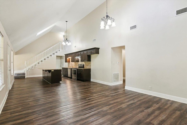 unfurnished living room with a high ceiling, dark hardwood / wood-style flooring, and a notable chandelier