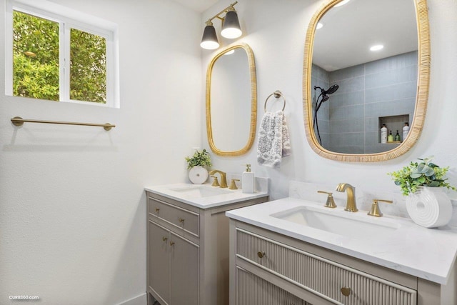 381 Perryman St, New Braunfels, TX 78130 - bathroom featuring a tile shower, two vanities, and a sink