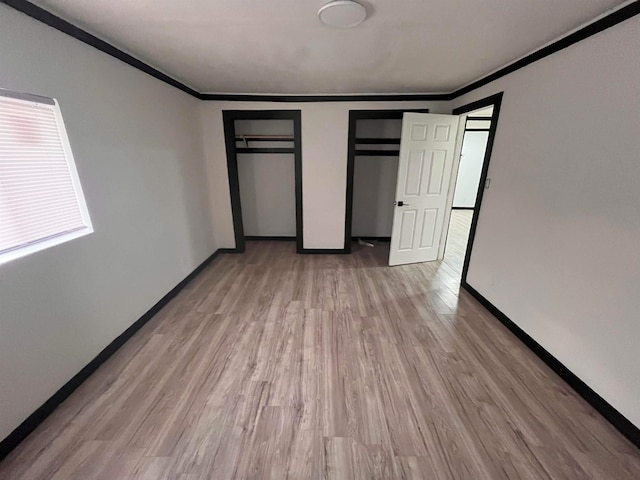 unfurnished bedroom featuring light hardwood / wood-style flooring and ornamental molding