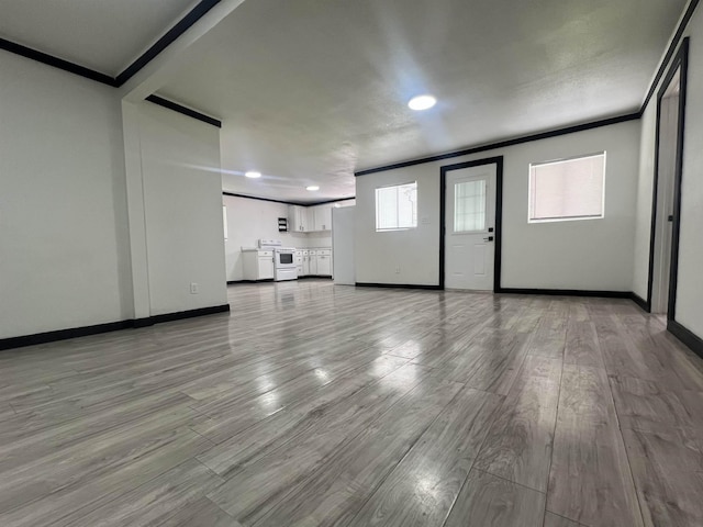 unfurnished living room with light hardwood / wood-style flooring and crown molding