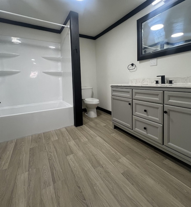 full bathroom with vanity, shower / washtub combination, crown molding, hardwood / wood-style floors, and toilet