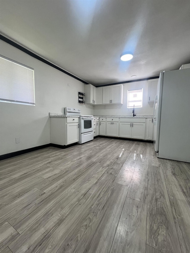 kitchen featuring light wood-type flooring, light stone counters, white appliances, sink, and white cabinets