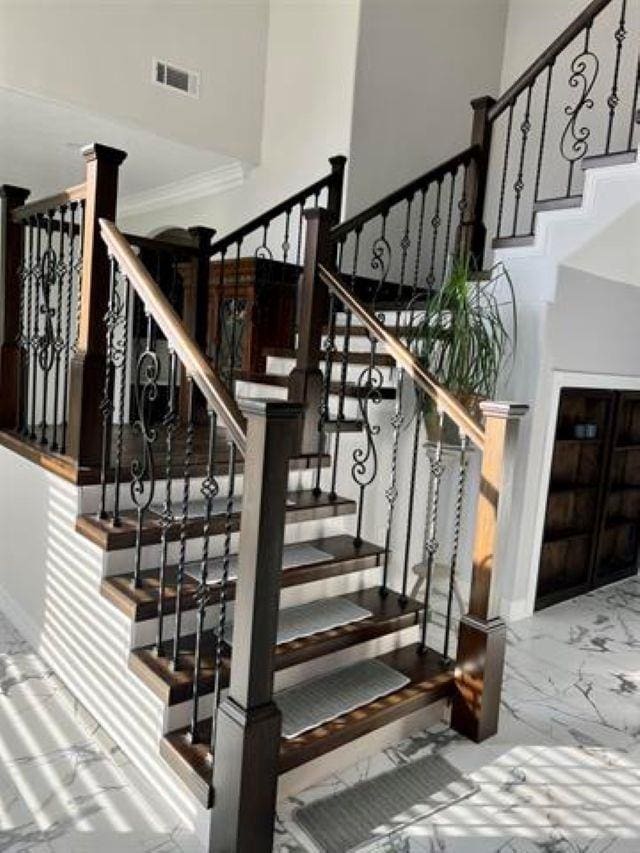 7600 Oakmont Dr, Port Arthur, TX 77642 - stairway with a towering ceiling, marble finish floors, crown molding, and baseboards