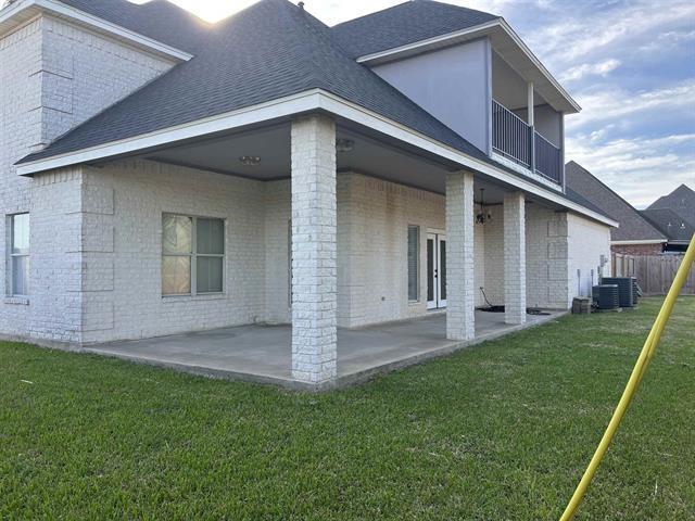7600 Oakmont Dr, Port Arthur, TX 77642 - back of property with brick siding, a patio area, and roof with shingles