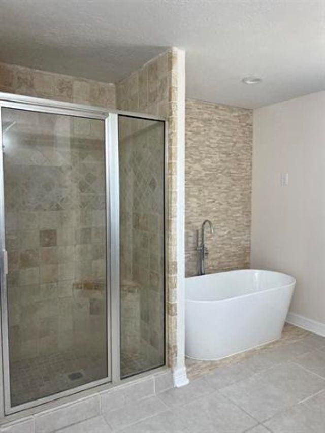 7600 Oakmont Dr, Port Arthur, TX 77642 - full bathroom with a freestanding bath, a shower stall, baseboards, and tile patterned floors