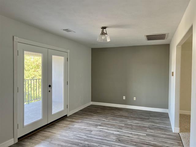 7600 Oakmont Dr, Port Arthur, TX 77642 - unfurnished dining area with french doors, wood finished floors, and baseboards