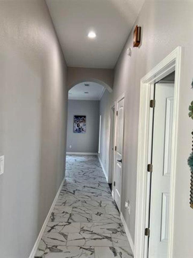 7600 Oakmont Dr, Port Arthur, TX 77642 - corridor with arched walkways, baseboards, and light marble finish floors