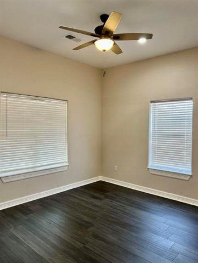 7600 Oakmont Dr, Port Arthur, TX 77642 - unfurnished room with baseboards, ceiling fan, and dark wood-type flooring
