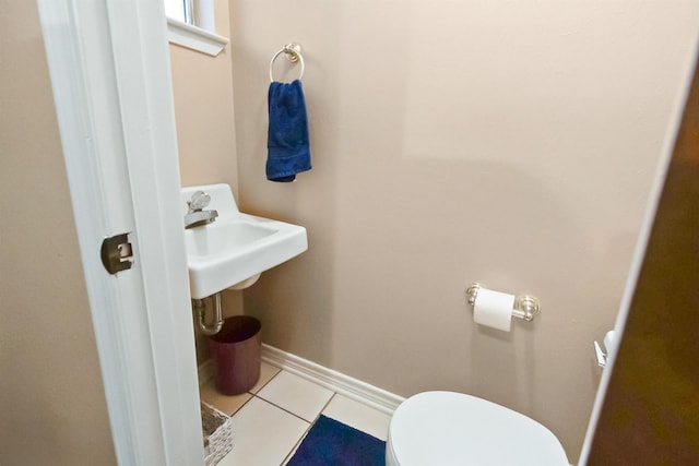 bathroom with tile patterned floors, baseboards, and toilet