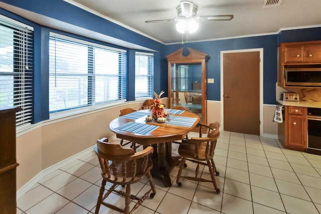 dining room with light tile patterned floors, ceiling fan, baseboards, ornamental molding, and visible vents