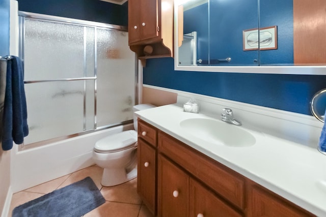 bathroom featuring vanity, enclosed tub / shower combo, toilet, and tile patterned flooring