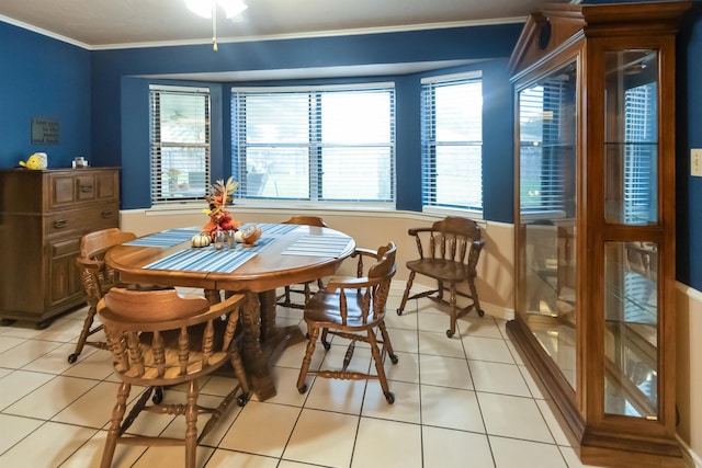dining space featuring baseboards, ornamental molding, and light tile patterned floors