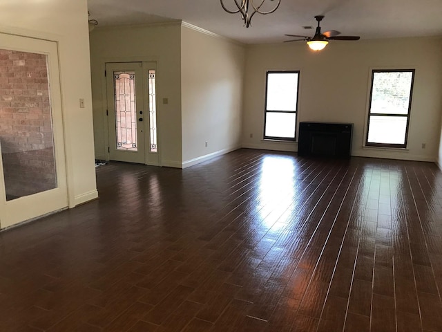 12 Encore Cir, Orange, TX 77630 - unfurnished living room with baseboards, a healthy amount of sunlight, dark wood-style floors, and ceiling fan with notable chandelier