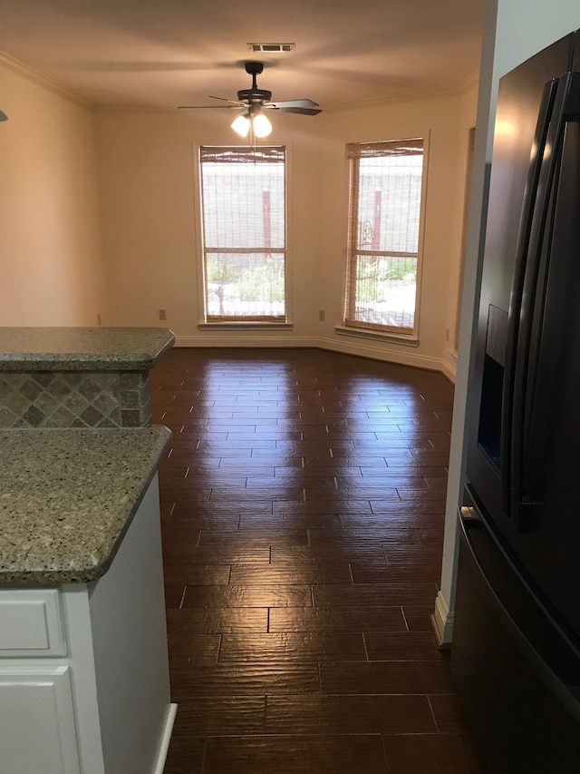 12 Encore Cir, Orange, TX 77630 - unfurnished dining area featuring a ceiling fan, baseboards, dark wood-style flooring, visible vents, and crown molding