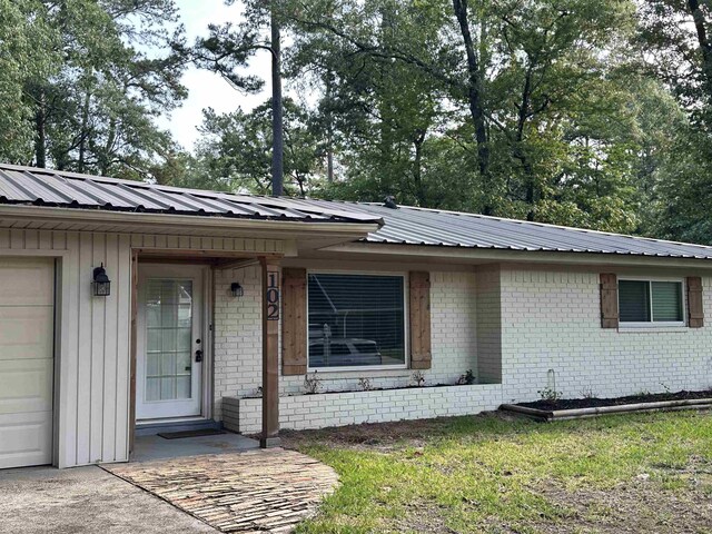 102 Ash Ln, Village Mills, TX 77663 - view of front facade featuring brick siding and metal roof
