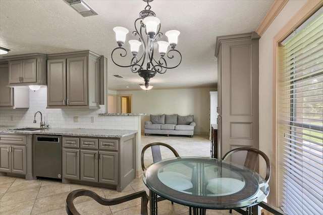 kitchen with sink, light stone counters, stainless steel dishwasher, pendant lighting, and light tile patterned floors