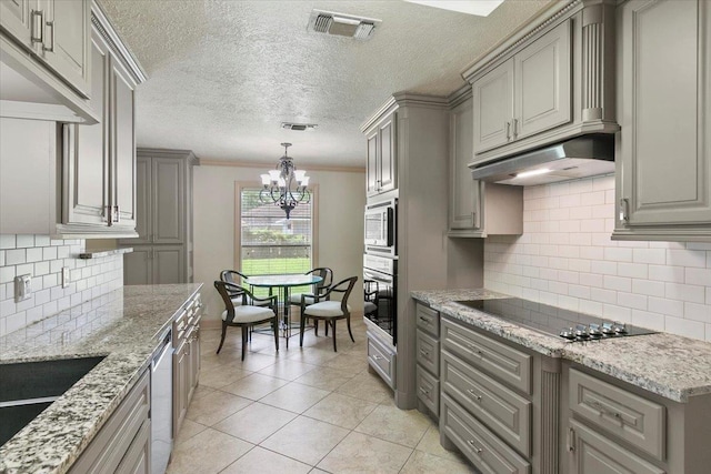 kitchen featuring black electric stovetop, oven, crown molding, built in microwave, and a notable chandelier