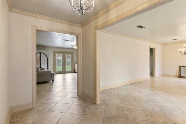 corridor with french doors, a textured ceiling, an inviting chandelier, and ornamental molding