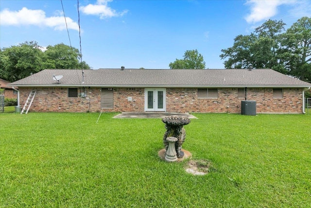 rear view of property with cooling unit, a yard, and french doors