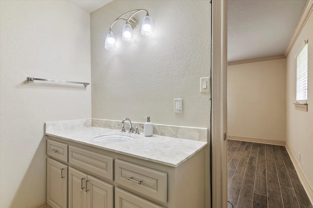 bathroom with hardwood / wood-style floors, vanity, and ornamental molding