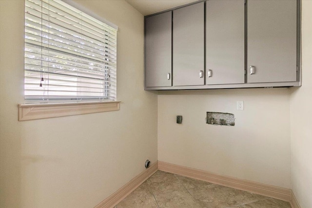 washroom featuring cabinets, hookup for a washing machine, light tile patterned floors, and electric dryer hookup