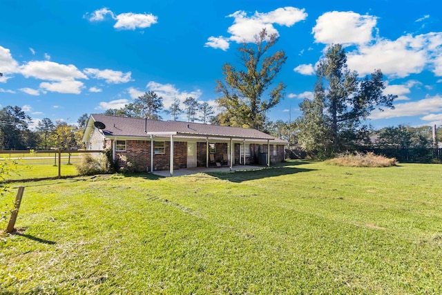 back of house with a lawn and a patio area