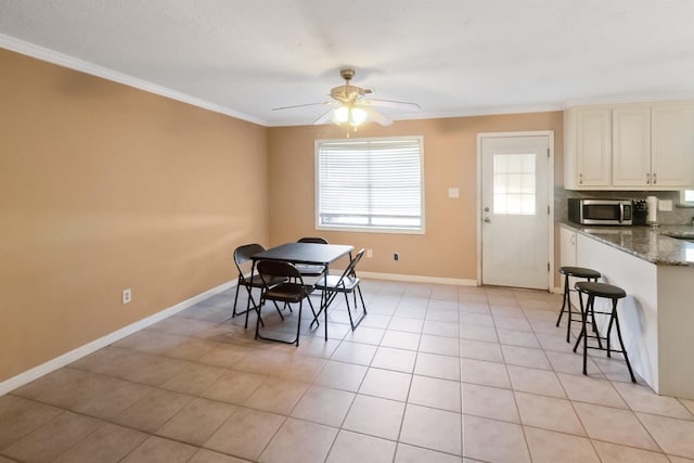 dining room with ceiling fan, light tile patterned flooring, and ornamental molding