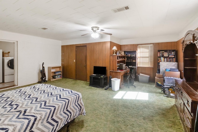 bedroom with ceiling fan, washer / dryer, carpet floors, and wooden walls