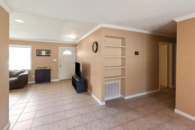 foyer entrance featuring light tile patterned floors, a textured ceiling, and crown molding